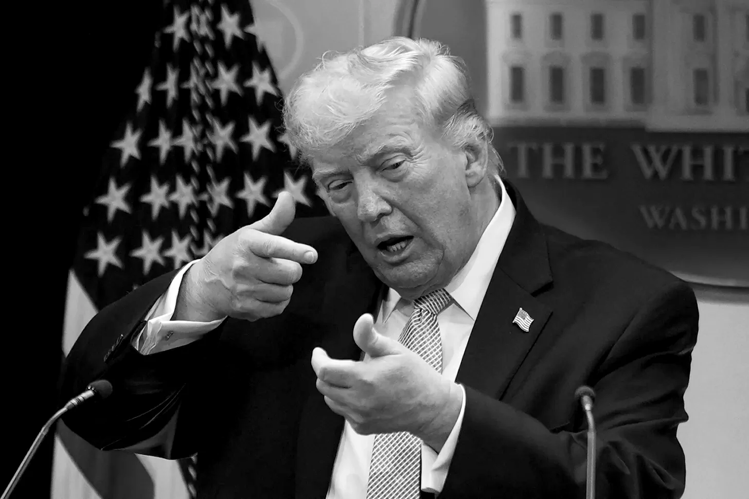 President Donald Trump pretends to aim a sniper gun while speaking with reporters